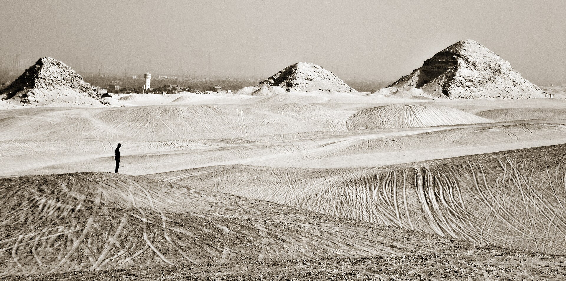 Pyramid silhouettes seen across the desert plateau at dawn
